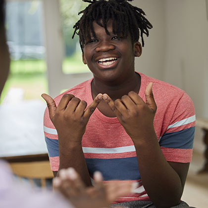 a young person doing a hand gesture
